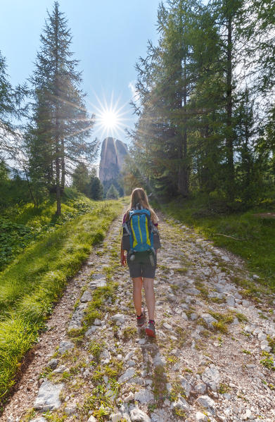 Woman walks towards Cinque Torri, Belluno, Dolomiti Ampezzane, Veneto, Italy, Western Europe