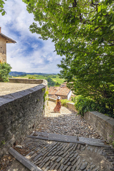 A woman walks on the staircase of Serralunga D'Alba Castle, Cuneo, Langhe e Roero, Piedmont, Italy, Southern Europe