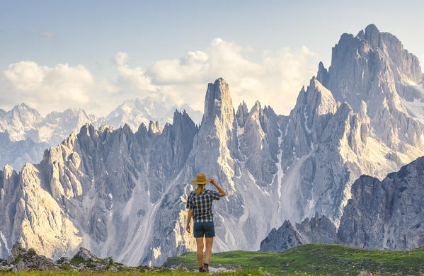 A woman observes Cadini di Misurina at sunset, Dolomiti di Sesto, Belluno, Veneto, Italy, Southern Europe