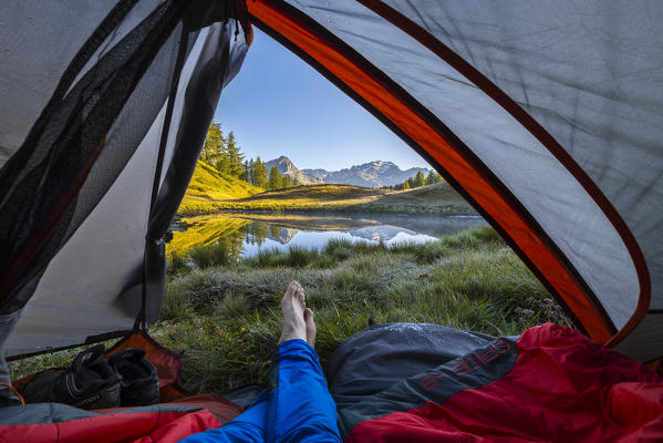 Man observes sunrise from his tent, Alpe Devero, Verbano Cusio Ossola, Piedmont, Italy, Southern Europe