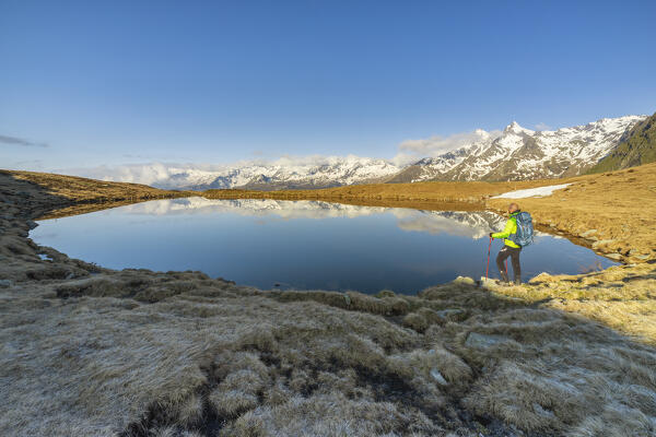 Man at Andossi Lake over Splugenpass at sunrise, Sondrio, Grigioni, Lombardy, Italy, Southern Europe (MR)