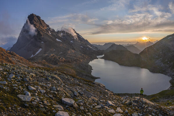 Aerial view of a Man at Rossa Pass and Geisspfadsee at sunset during summer, Alpe Devero, Val D’Ossola, Verbano Cusio Ossola, Piedmont, Italy, Western Europe
