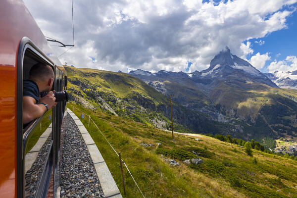 A tourist observes Matterhorn from the train of Gornergratbahn, Zermatt, Canton of Valais, Visp, Switzerland, Western Europe