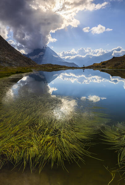 A man observes Matterhorn reflected in the Rifflesee lake during summer, Zermatt, Canton of Valais, Visp, Switzerland, Western Europe