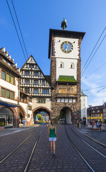 A woman observes Freiburg im Breisgau and its Schwabentor, Baden Wurttemberg, Germany, Deutschland, Western europe