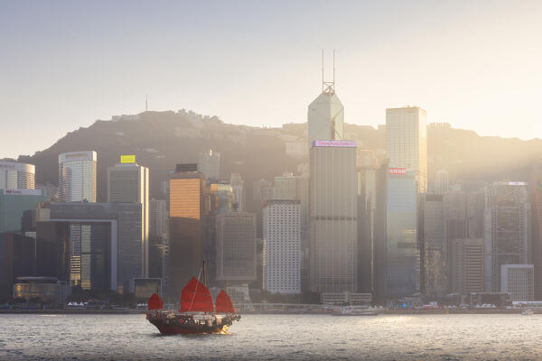 Ancient Dunkling boat sails in front of cityscape of Hong Kong during sunset, Tsim Sha Tsui, Kowloon, Hong Kong, China, Asia