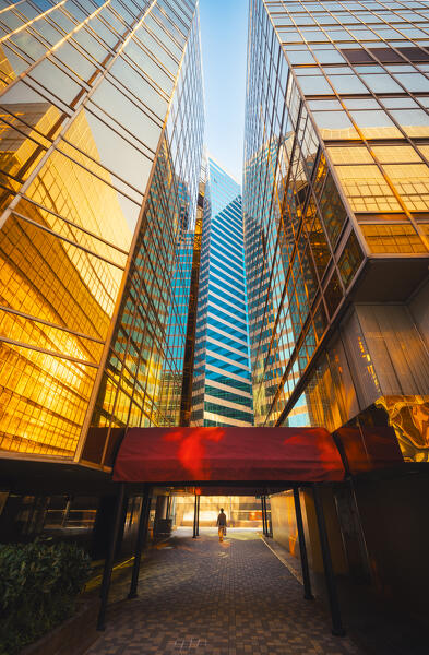 A person walks through the golden Royal Pacific Hotel at sunset, Tsim Sha Tsui, Kowloon, Hong Kong, China, Asia