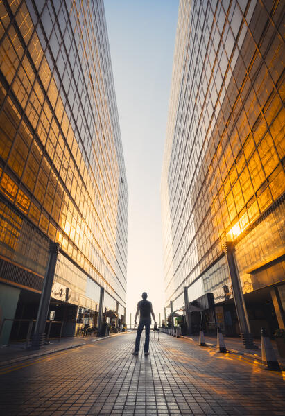 A person stands through the golden Royal Pacific Hotel at sunset, Tsim Sha Tsui, Kowloon, Hong Kong, China, Asia