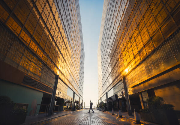 A person walks through the golden Royal Pacific Hotel at sunset, Tsim Sha Tsui, Kowloon, Hong Kong, China, Asia