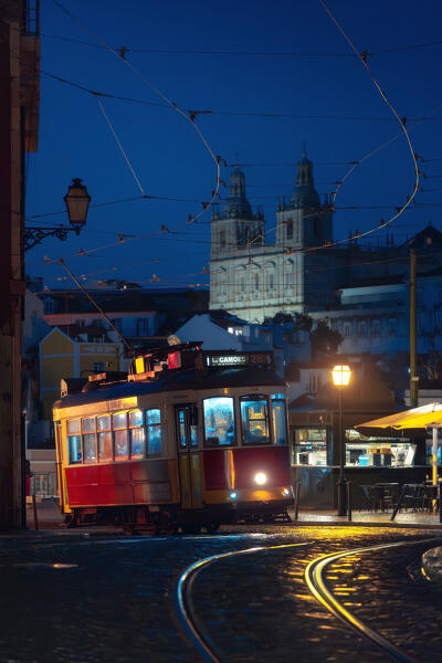 The iconic tram 28 in Lisbon with Sao Vicente de For a church in the background, Alfama, Lisbon, Portugal, Iberian peninsula, Western Europe