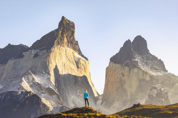 A tourist observes Cuernos del Paine during sunrise, Torres del Paine NP, Ultima Esperanza, Region de Magallanes y de la Antartica Chilena, Patagonia, Chile, South America