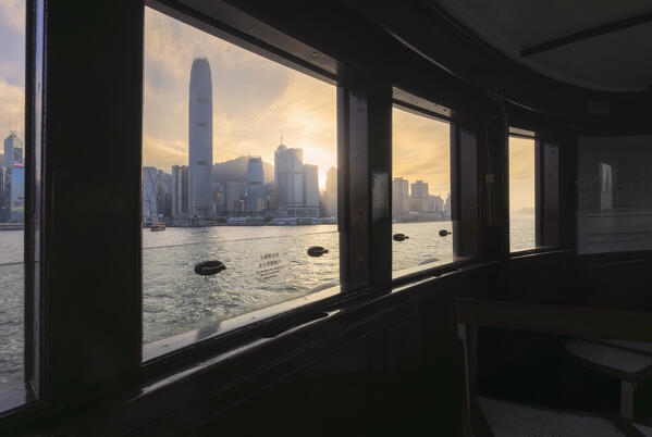 View of cityscape of Hong Kong during sunset from the window of a ferry boat, Tsim Sha Tsui, Kowloon, Hong Kong, China, Asia