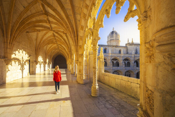 A tourist walks in the cloister of Jeronimos Monastery during sunset, Restelo, Belem, Lisbon, Portugal, Iberian peninsula, Western Europe