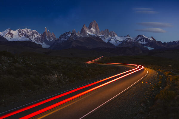 Trails of car lights along the main road to el Chalten with Fitz Roy in the background during sunrise, El Chalten, Parque Nacional Los Glaciares, Santa Cruz, Patagonia Argentina, Argentina, South America