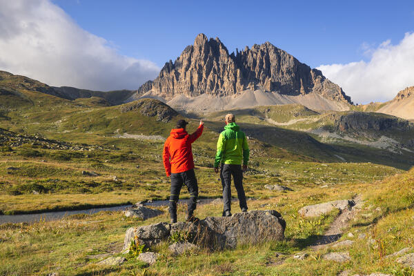 Two hikers in front of Grand Serù at sunset during summer, Provence Alps Cote d’Azur, Haute Alps, Vallee Etroite, France, Europe