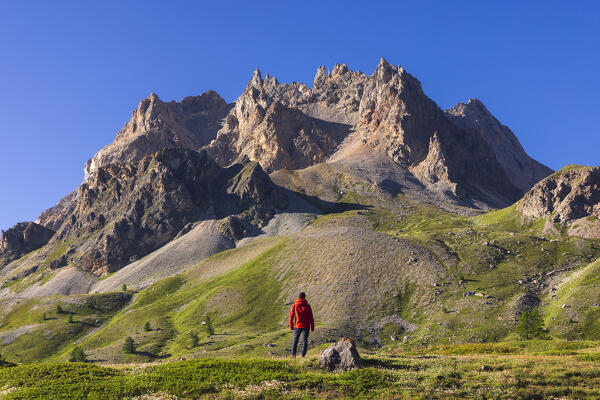 A hiker observes Pointe de l’Enfourant at sunrise during summer, Provence Alps Cote d’Azur, Haute Alps, Vallee Etroite, France, Europe