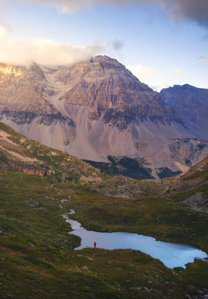 Aerial view of a hiker in front of  Lac Lavoir and mountains at sunset during summer, Provence Alps Cote d’Azur, Haute Alps, Vallee Etroite, France, Europe