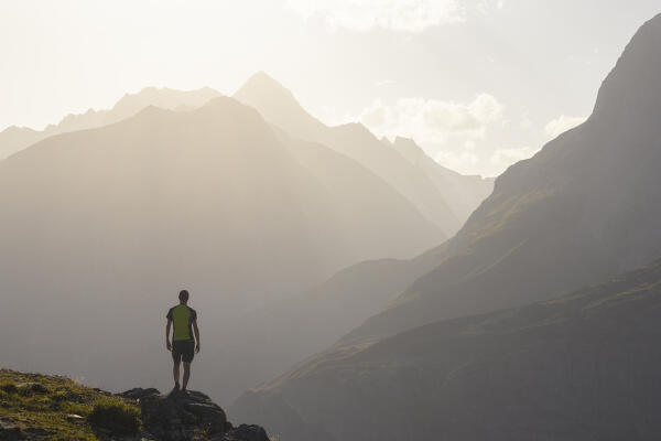 A trekker observes Nesthorn from Moosfluh viewpoint during sunset in summer, Riederalp, Canton of Valais, Oriental Raron, Switzerland, Western Europe