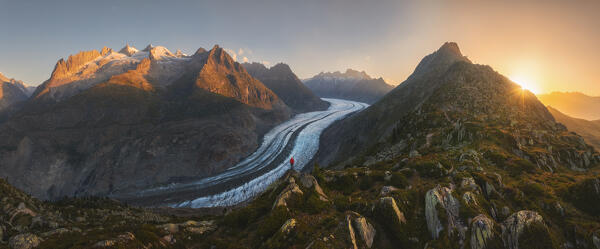 Panoramic and aerial view of a trekker while observing Aletsch glacier during sunrise in summer, Riederalp, Canton of Valais, Oriental Raron, Switzerland, Western Europe