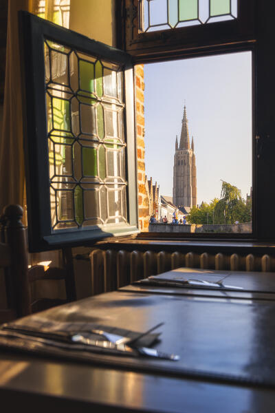 Church Onze Lieve Vrouwekerk framed by a window of a restaurant during sunset, Bruges, Belgium, West Flanders, Flanders, Western Europe