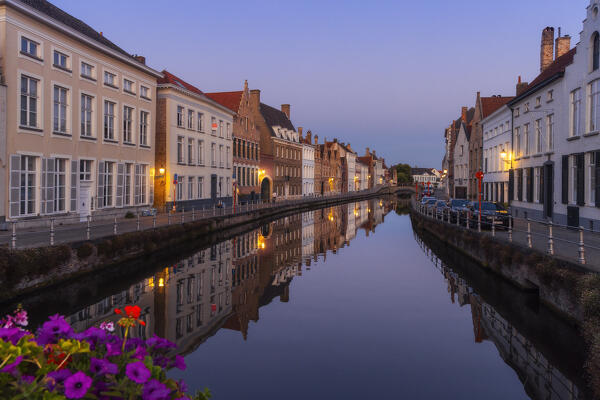 Illuminated river banks and houses reflected in the canal at dusk, Bruges, Belgium, West Flanders, Flanders, Western Europe 