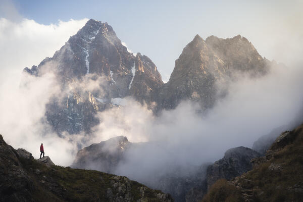 A trekker in front of Monviso near Fiorenza Lake, Crissolo, Cuneo, Piedmont, Italy, Southern Europe