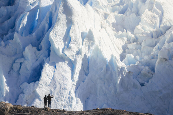 A couple observes glacier front of Perito Moreno, Parque Nacional Los Glaciares, El Calafate, Santa Cruz, chilean antarctica region, Patagonia Argentina, Argentina, South America