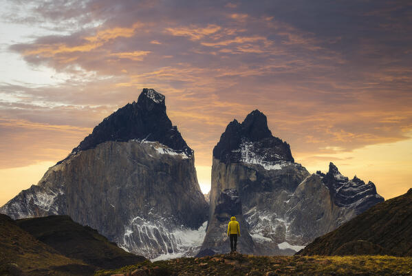 A tourist observes Cuernos del Paine during sunset, Torres del Paine NP, Ultima Esperanza, Region de Magallanes y de la Antartica Chilena, Patagonia, Chile, South America