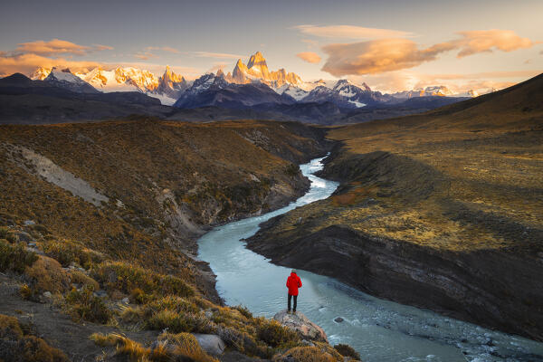 Elevated view of a tourist observes Fitz Roy mountain during sunrise over river, El Chalten, Parque Nacional Los Glaciares, Santa Cruz, Patagonia Argentina, Argentina, South America
