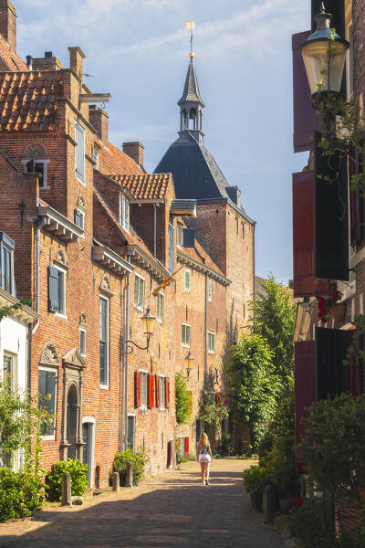 A tourist walks in front of Dieventoren in Amersfoort during summer, Amersfoort, Netherlands, Utrecht, Western Europe (MR)