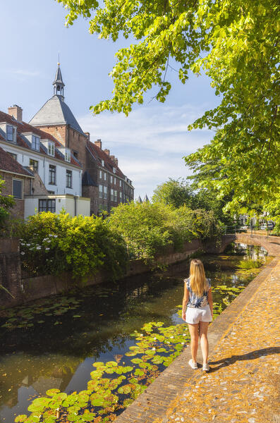 A tourist observes Dieventoren along the canal in Amersfoort during summer, Amersfoort, Netherlands, Utrecht, Western Europe