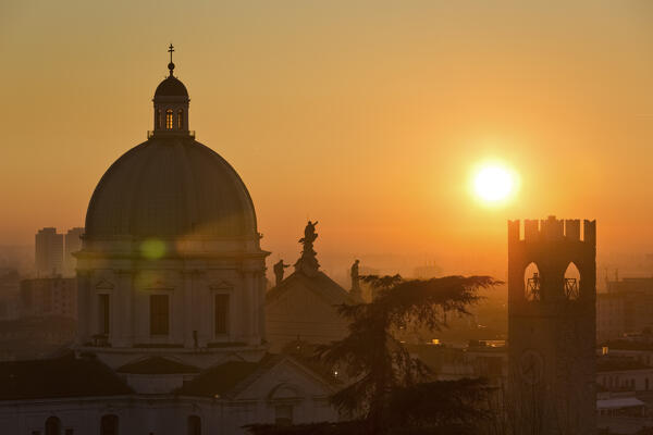 The Cathedral of Santa Maria Assunta and the Pegol Tower of Palazzo Broletto at sunset. Brescia, Lombardy, Italy.