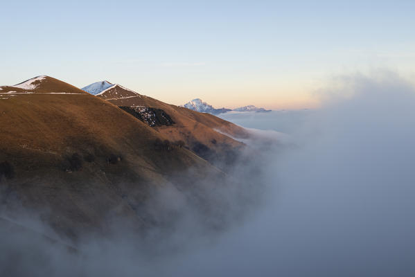 Monte Galbiga, Como province, Lombardy, Italy, Europe. Clouds rising up and Grigne in the background during sunset