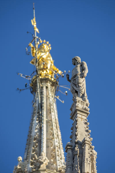 Milan, Lombardy, Italy, Europe. Close up of the Madonnina golden statue on top of Milano Cathedral