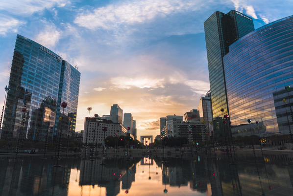 La Défense’s Skyscrapers and Arc de la Défense reflected in a fountain at sunset (Paris, Ile-de-France, France, Europe)