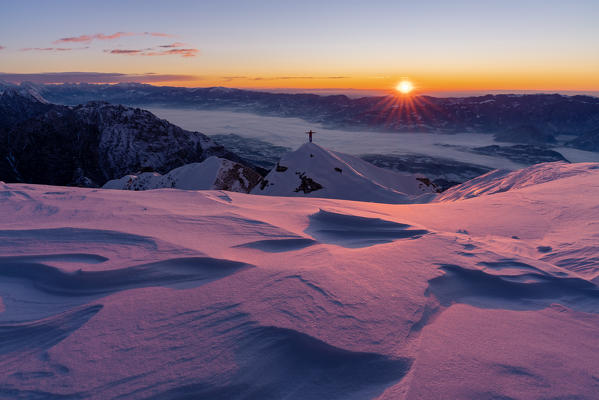 Hiker enjoys the sunrise on the top of Col Cesta, Feltre, Belluno province, Italy, Europe