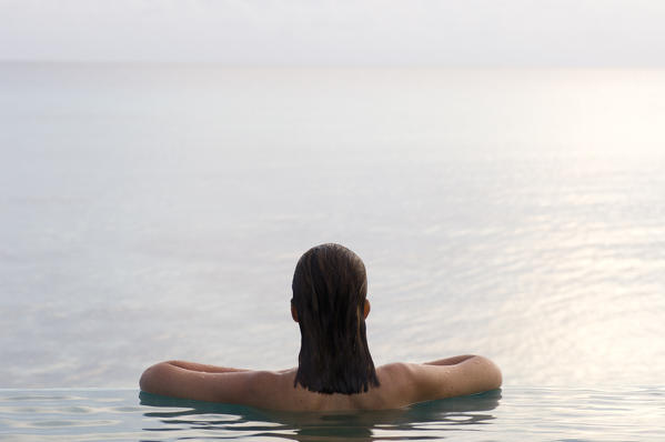 Woman relaxing in infinity pool. Rangiroa, Tuamotu Archipelago, French Polynesia. (MR)