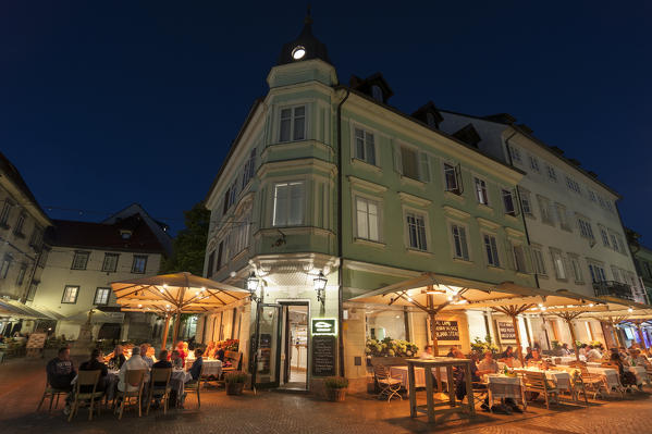Outdoor cafes and restaurants along the Ljubljanica river at night, Ljubljana, Slovenia.