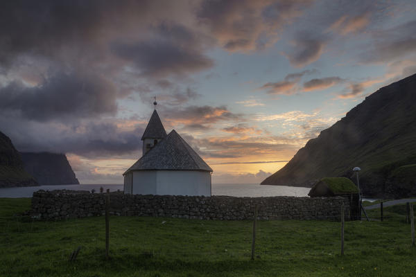 Europe, Denmark, Faroe Islands, Vidoy, Vidareidi: a classic little church on the coastline at sunset