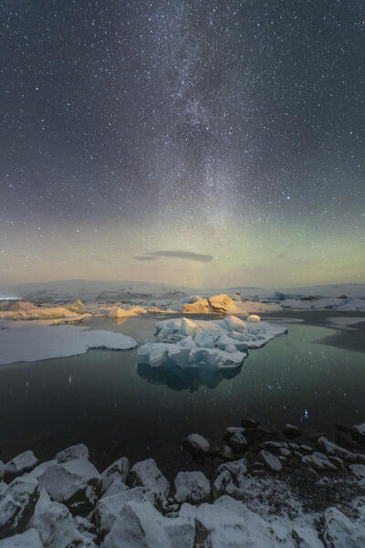 Europe, Southern Iceland: the icebergs of Jokulsarlon Lagoon under a million stars sky, the Milky Way and the Aurora Borealis