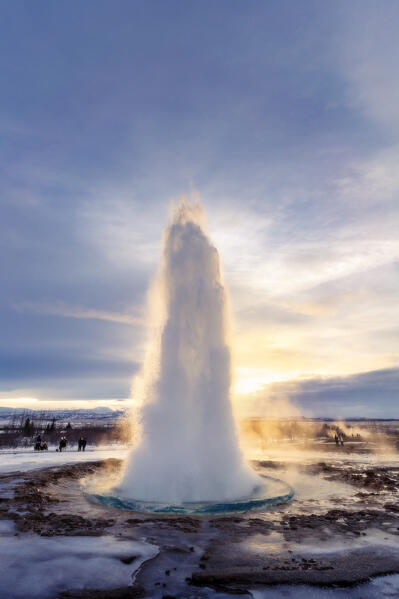 Europe, Southern Iceland, the Golden Circle: Strokkur, the Great Geyser explodes in front of the sunset in the Haukadalur geothermal area