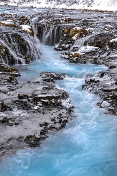 Europe, Southern Iceland: the blue waters Bruararfoss flow in the dark lava rocks