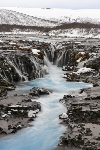 Europe, Southern Iceland: the blue waters Bruararfoss flow in the dark lava rocks