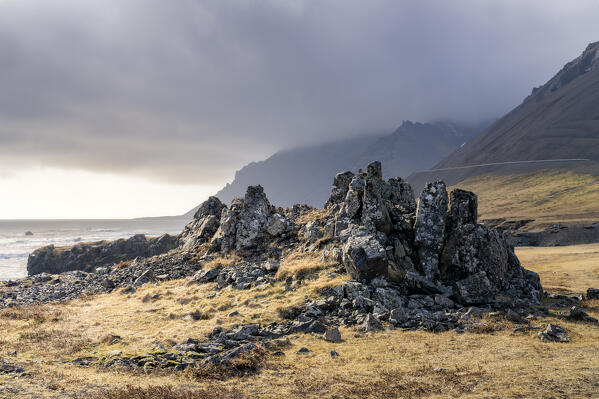 Evening lights after a storm on rock formations on the shoreline: Eastern Iceland, Europe 