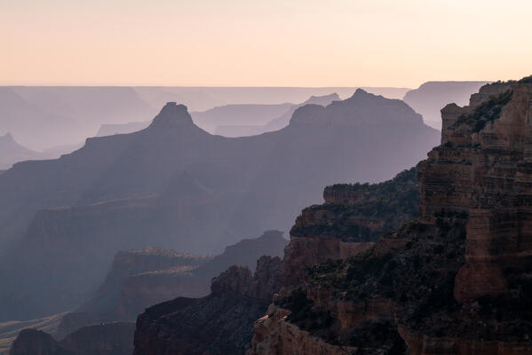 Sunset lights through the shapes of the Grand Canyon; North Rim of the Grand Canyon National Park, Arizona, United States of America