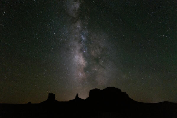 A million stars night with the Milky Way shining over the Monument Valley's silhouette; Arizona and Utah, United States of America
