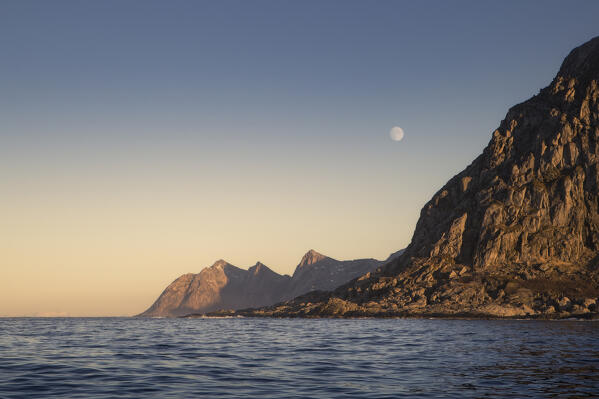 Last lights before sunset with the Moon among the fjords in the Arctic Norway: Europe