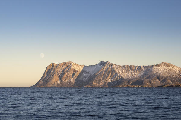 Last lights before sunset with the Moon among the fjords in the Arctic Norway: Europe