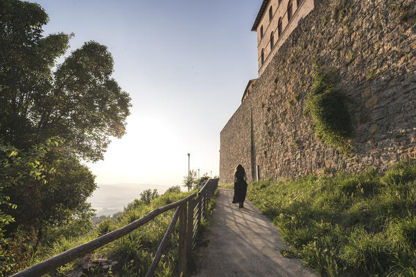 A young woman walking into a panoramic path in Volterra, Pisa province, Tuscany, Italy, Europe