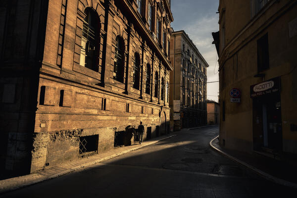 A person is walking down the street during sunset. Perugia, Perugia Province, Umbria, Italy,Europe